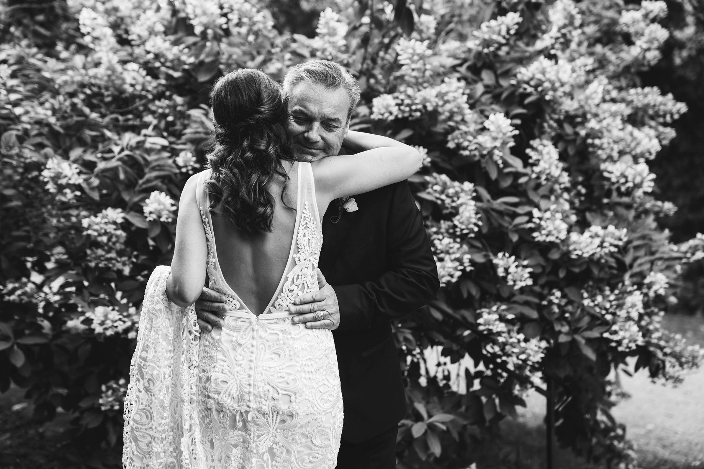 A documentary photograph of a bride hugging her father before her Willowdale Estate wedding