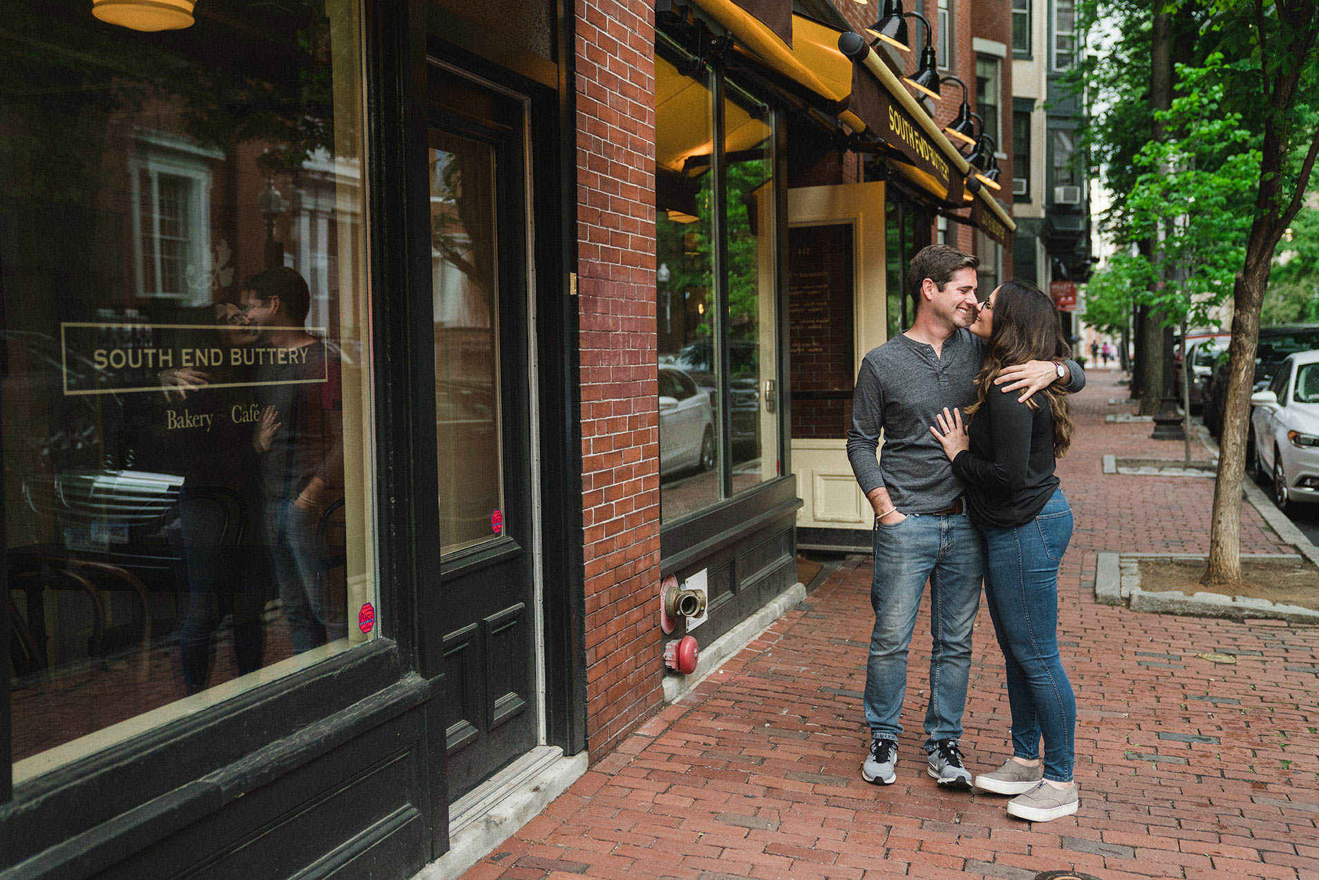 A documentary portrait of a couple hugging outside of the Southend Buttery during their Boston engagement session