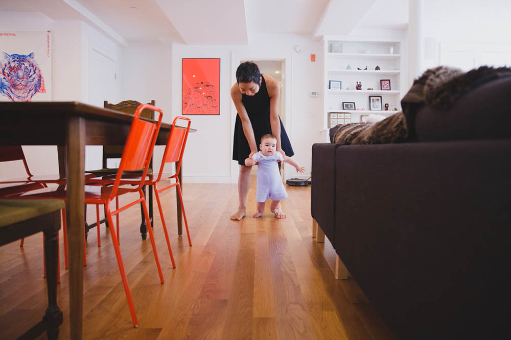 A documentary photograph of mom walking with her son during an in home family session in Boston's Jamaica Plain
