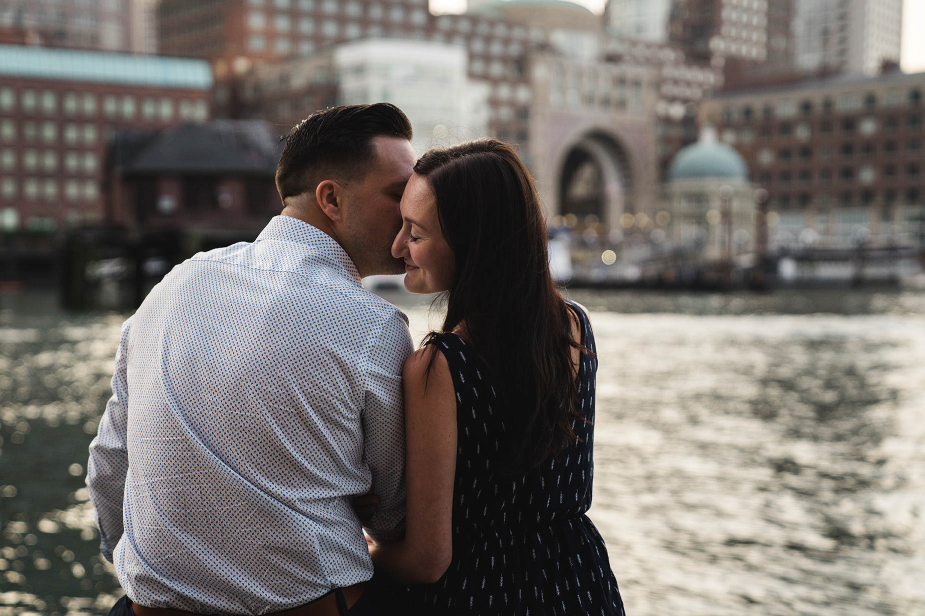 A documentary portrait of a couple kissing at Fan Pier during their Boston engagement session