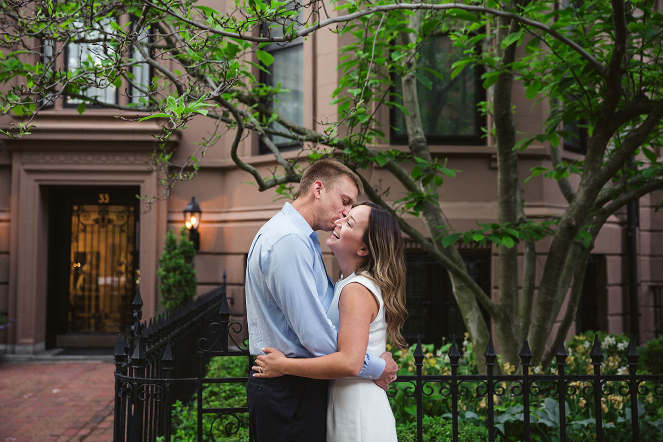 A documentary portrait of a couple hugging outside their Back Bay home during their Boston engagement session