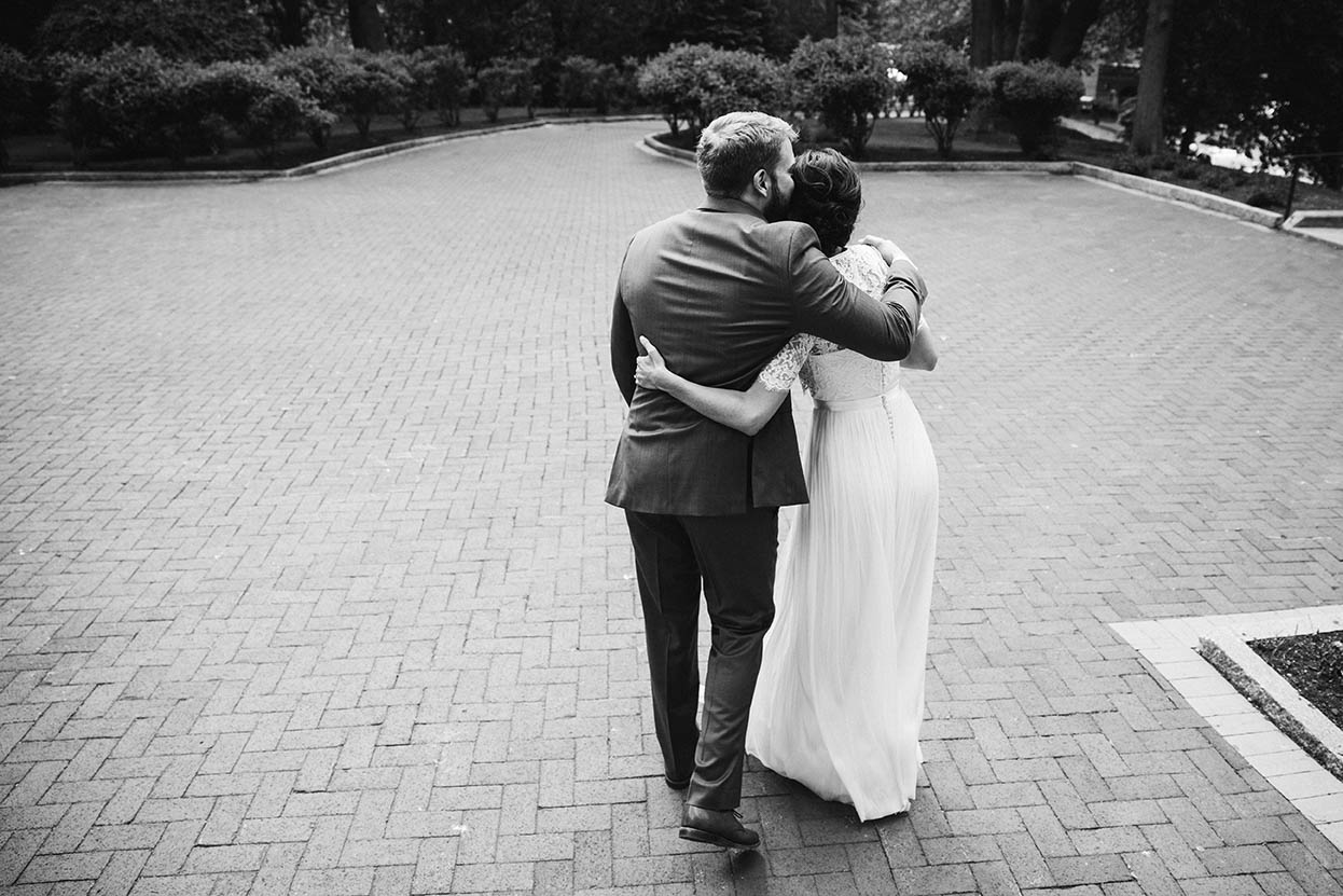A documentary photograph of a bride and groom hugging just after they married each other in Boston