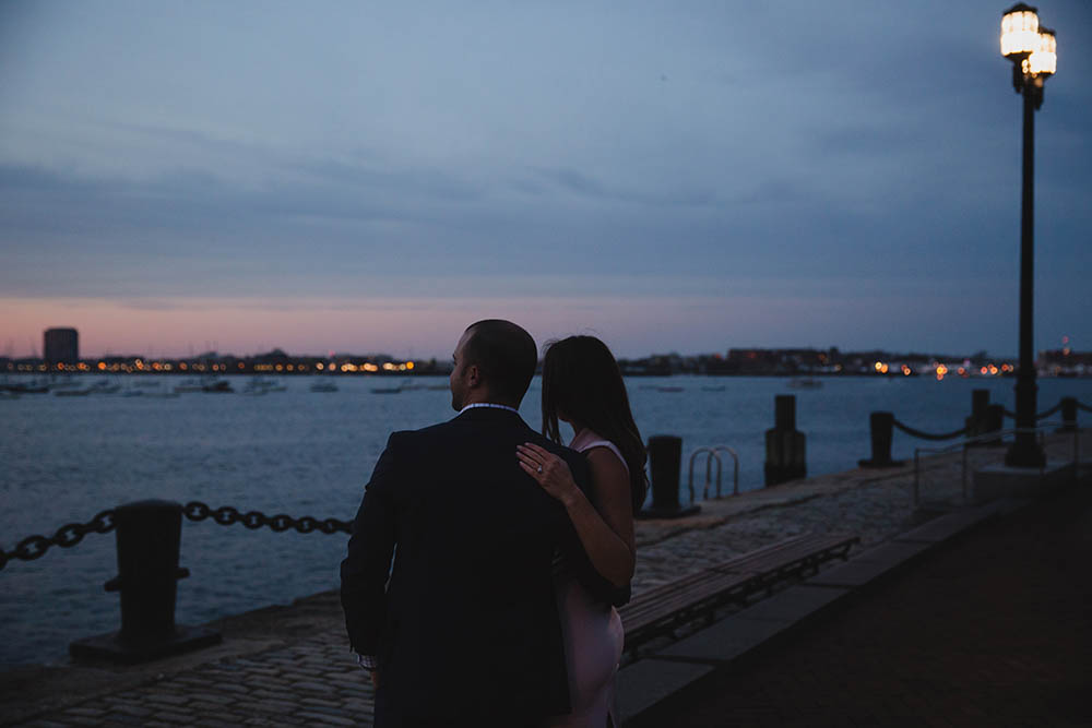 A documentary portrait of a couple hanging out for the sunset at Fan Pier during their Boston engagement session