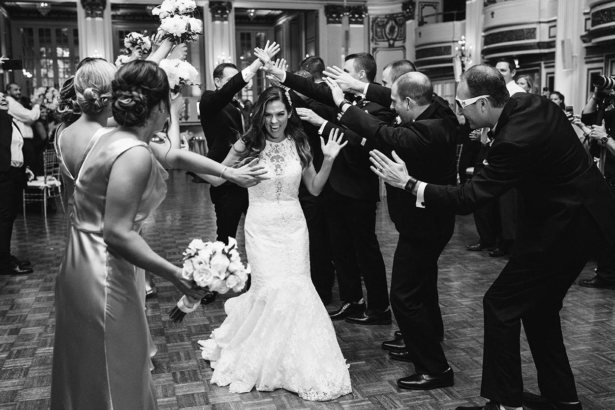 A documentary photograph of bride and groom entering their wedding reception at Fairmont Copley in Boston