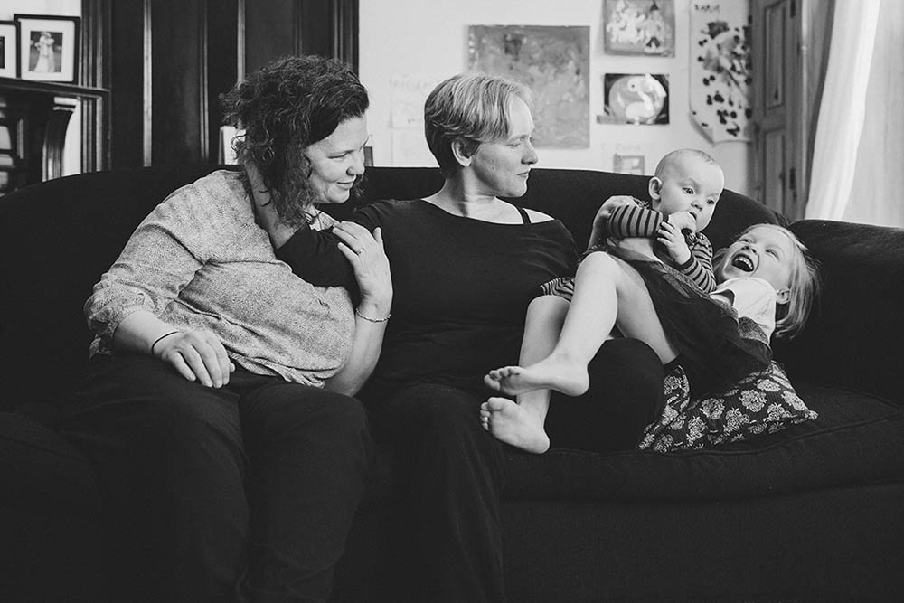 A documentary photograph of a family hanging out on the couch during their in home family session in Boston