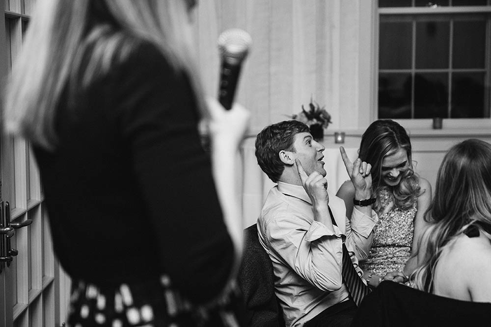 A documentary photograph of wedding guests laughing during the speeches at a Boston wedding
