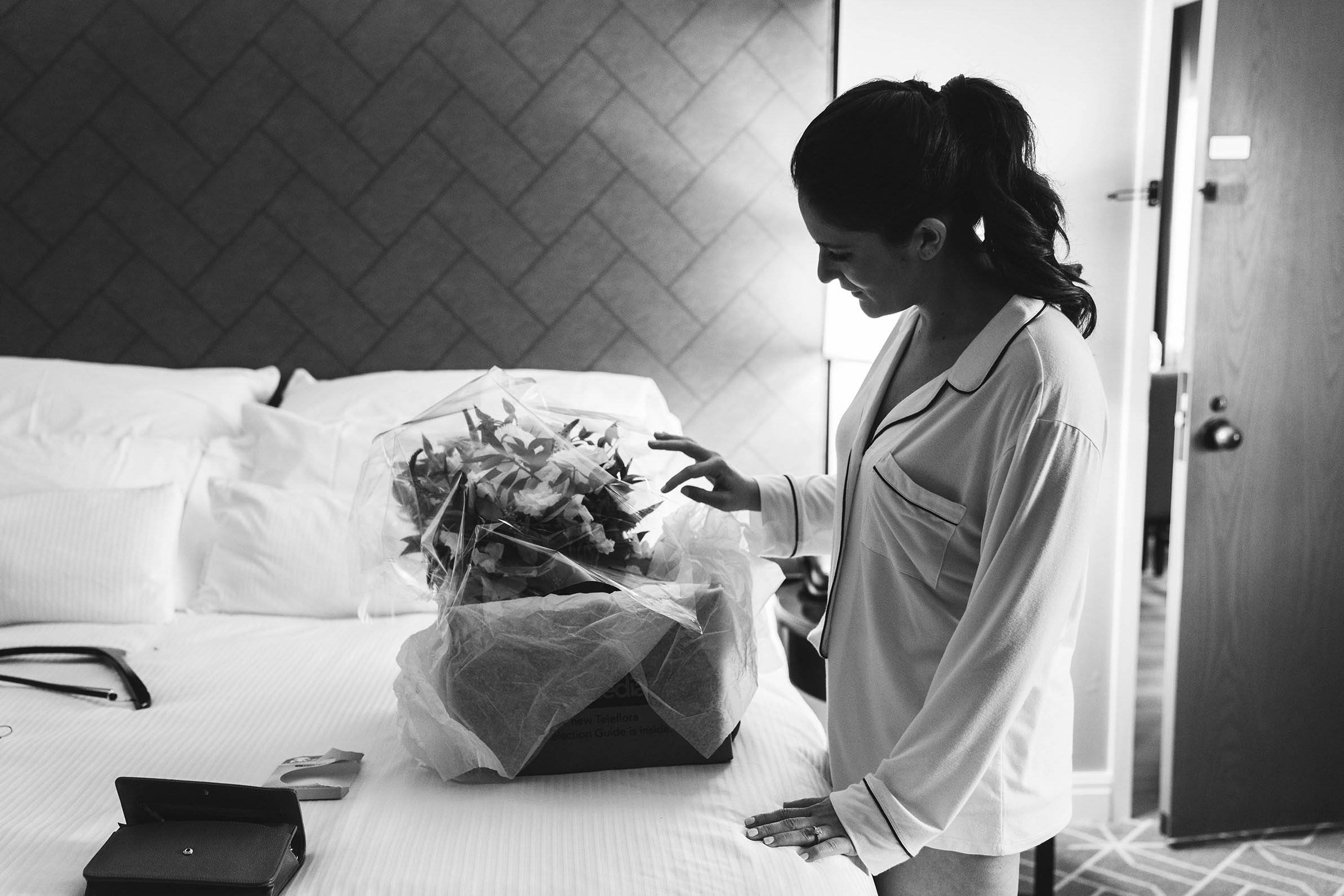A documentary photograph of a bride looking at her bouquet before her Cyclorama wedding in Boston's South End