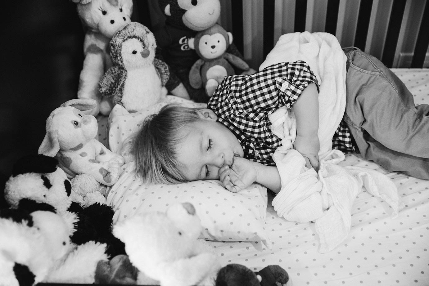 A documentary photograph of boy sleeping in his bed during an in home family session in Boston