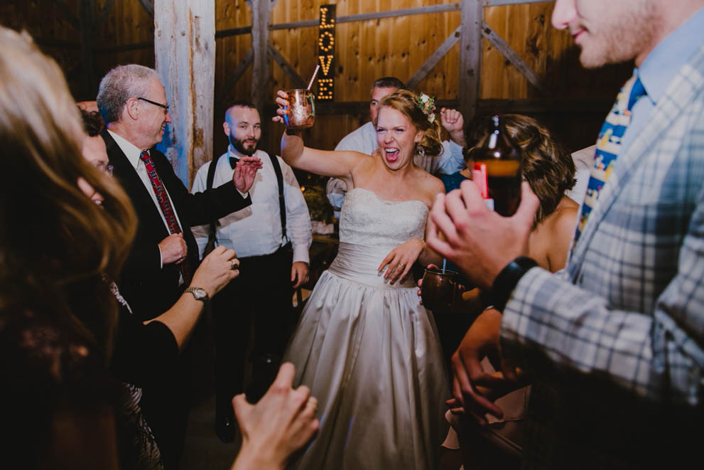 A documentary photograph of a bride celebrating during her Kitz Farm wedding in New Hampshire