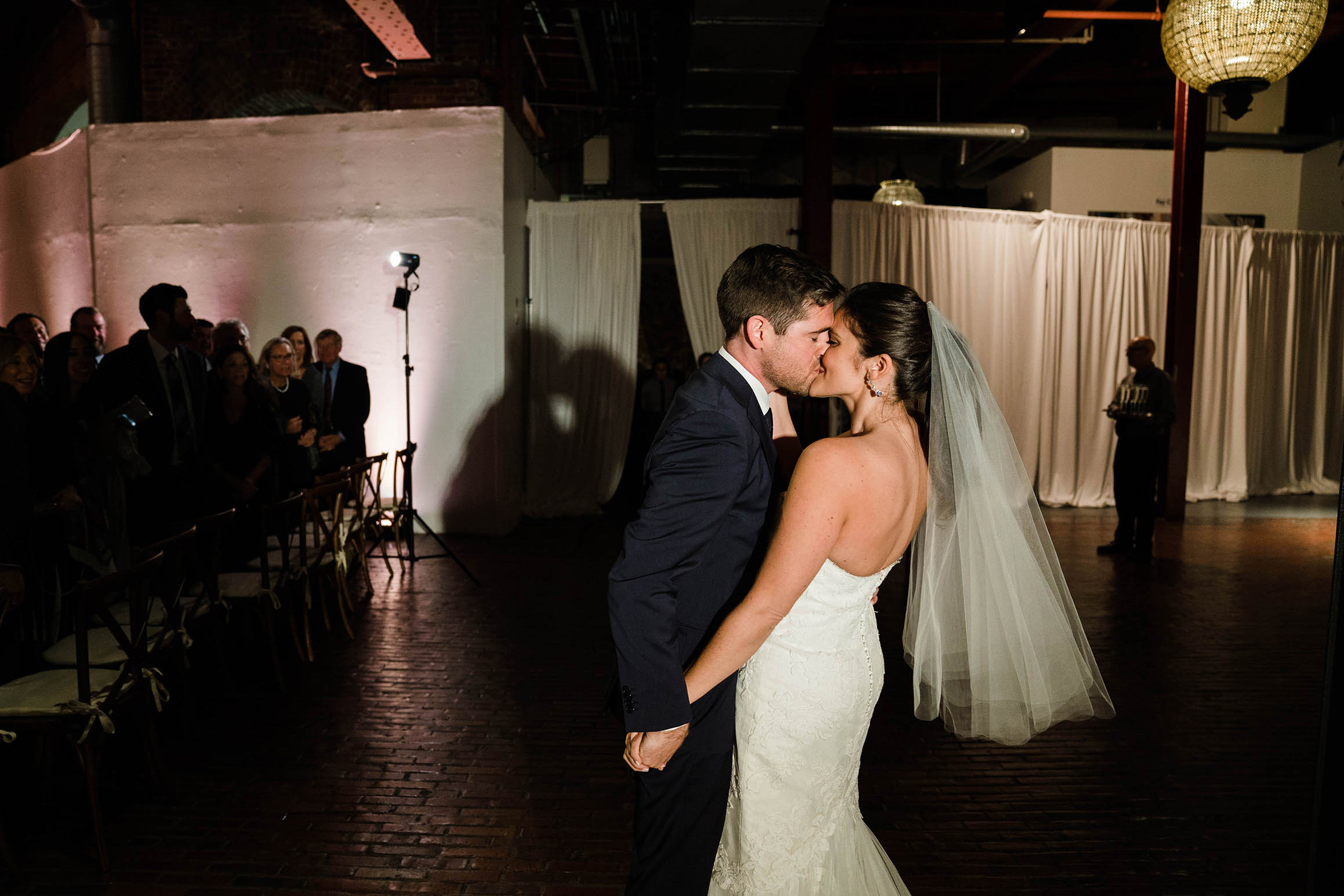 A documentary photograph of a bride and groom kissing after they walked down the aisle during their Cyclorama wedding in Boston's South End