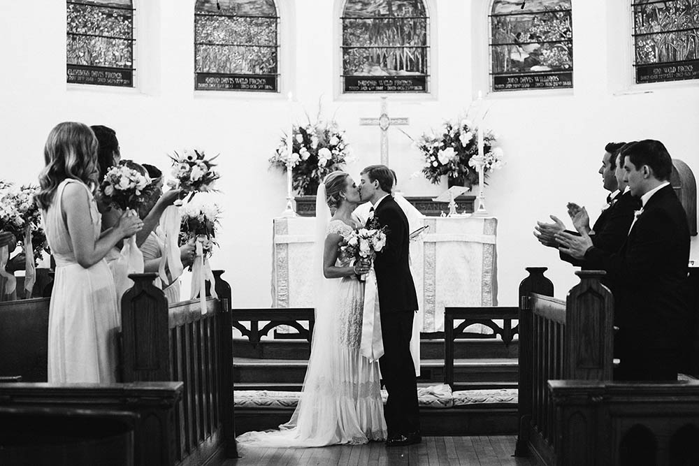A documentary photograph of a bride and groom kissing during their wedding ceremony on Nantucket