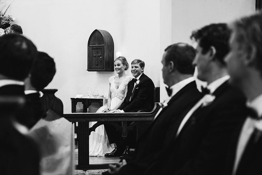 A documentary photograph of a bride and groom laughing during their wedding ceremony on Nantucket