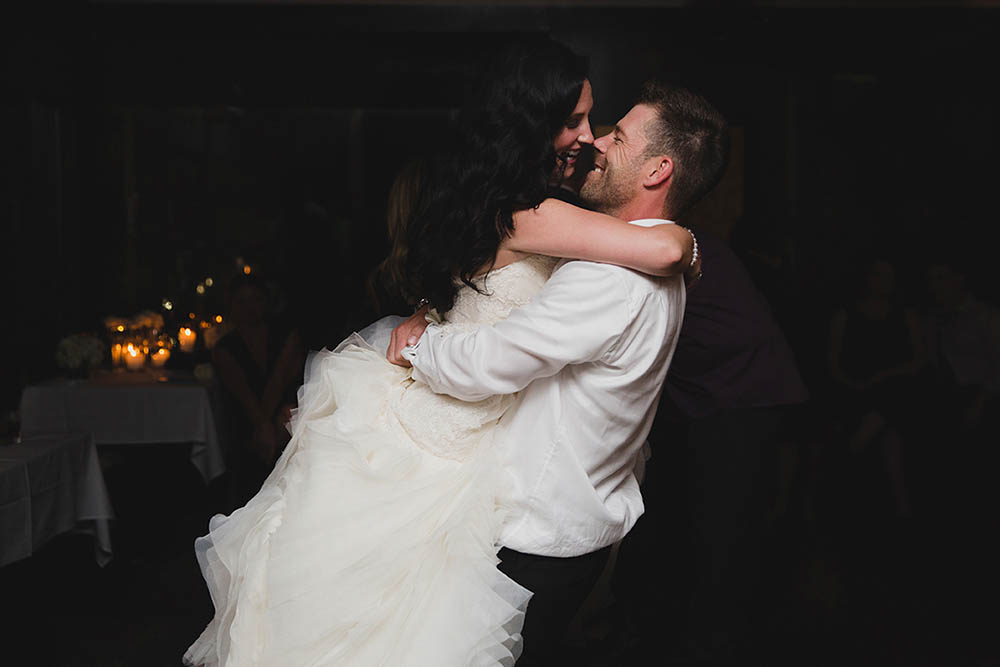 A documentary photograph of a bride and groom hugging on the dance floor during their wedding at Marliave Restaurant in Boston