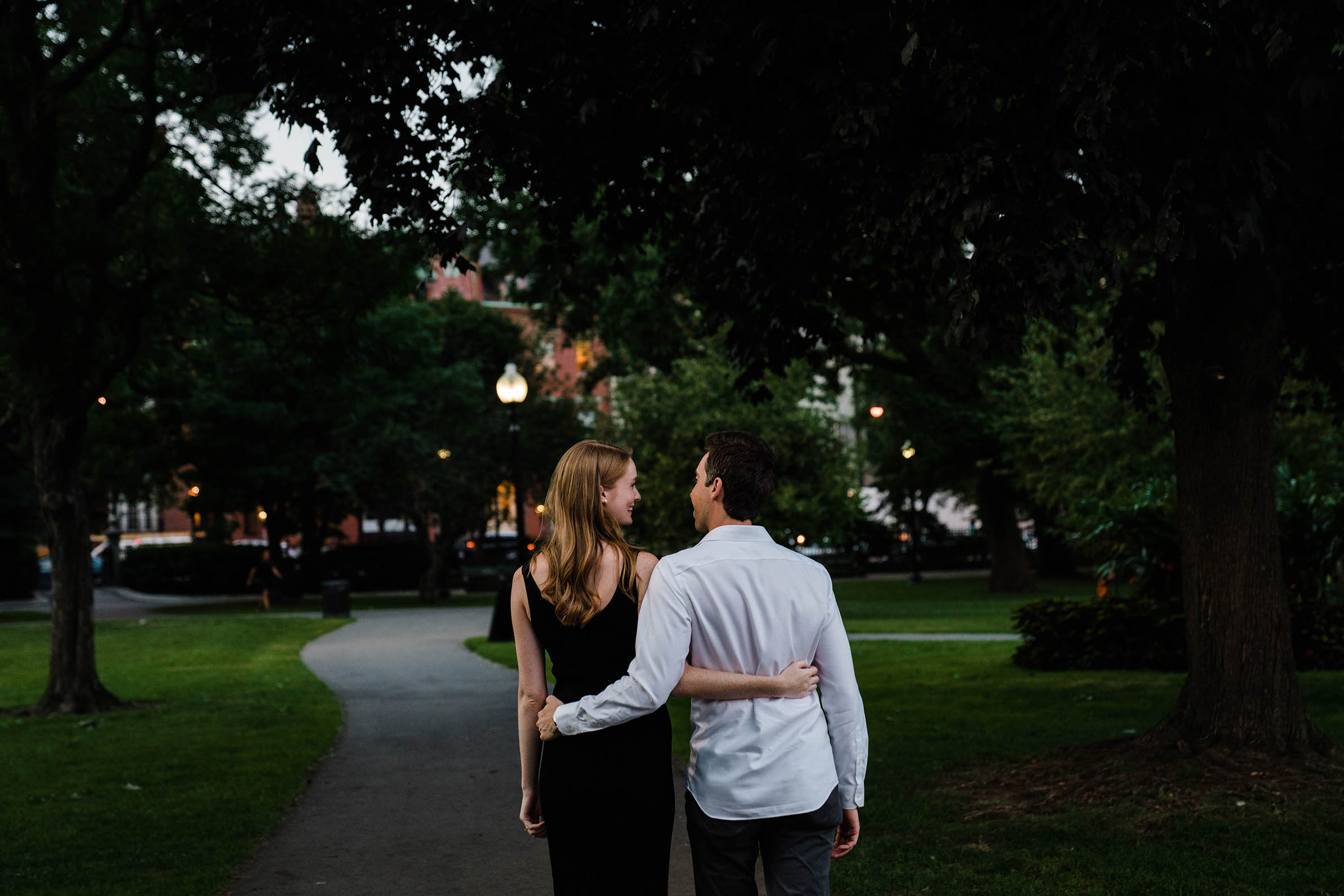A documentary portrait of a couple walking together at the Public Gardens during their Boston engagement session