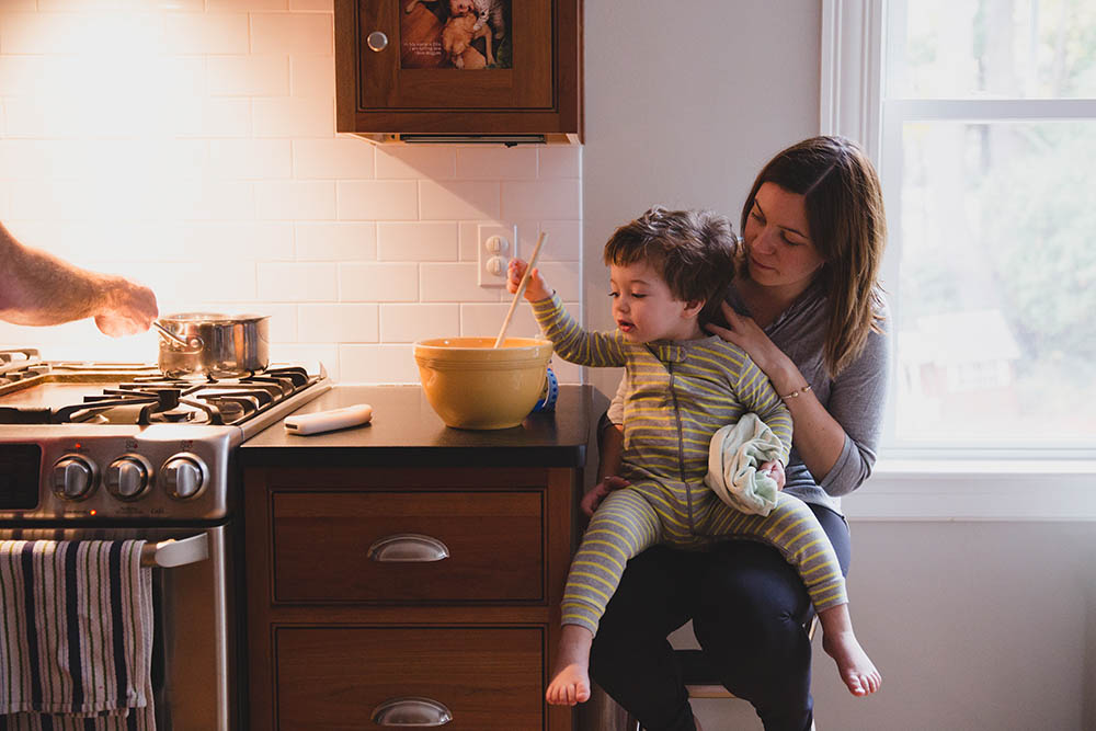 A documentary photograph of family making pancakes during their in home family session in Boston