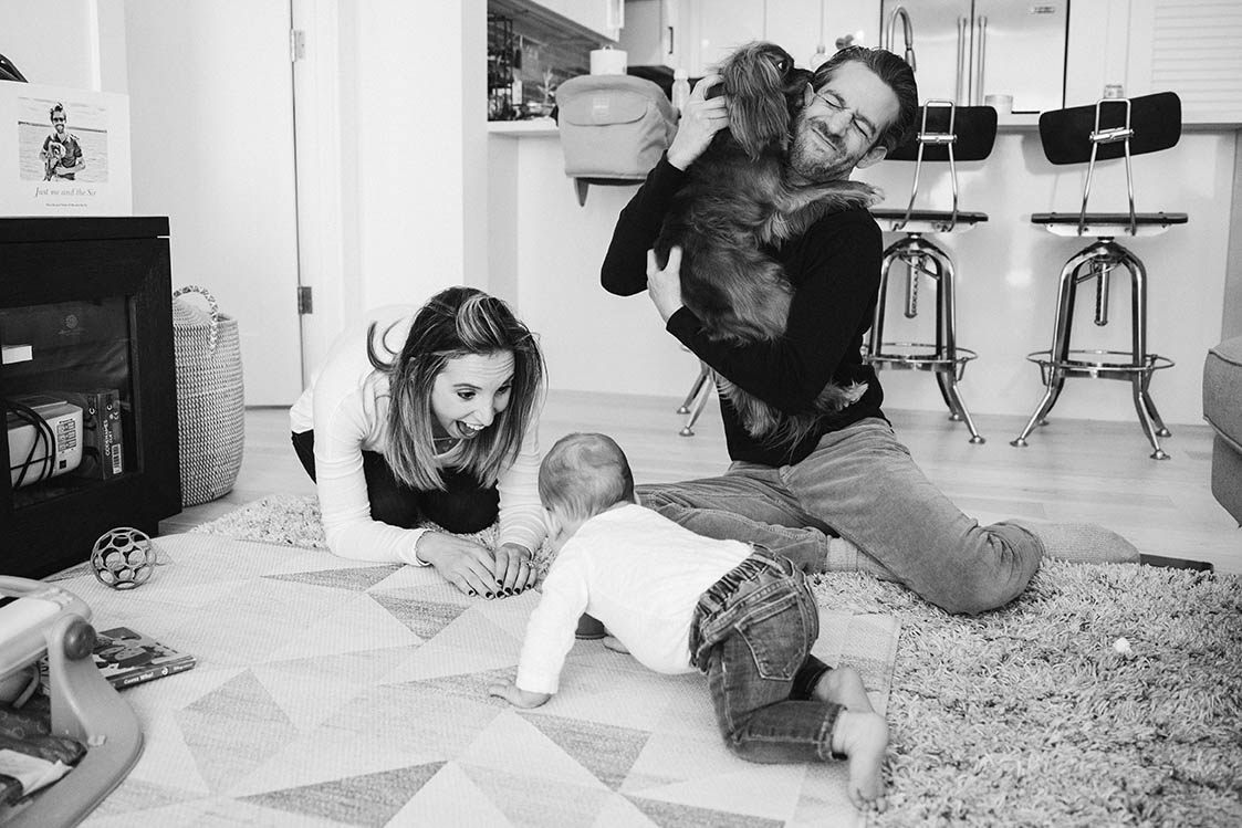 A documentary photograph of a family playing in their living room during an in home family session in Boston
