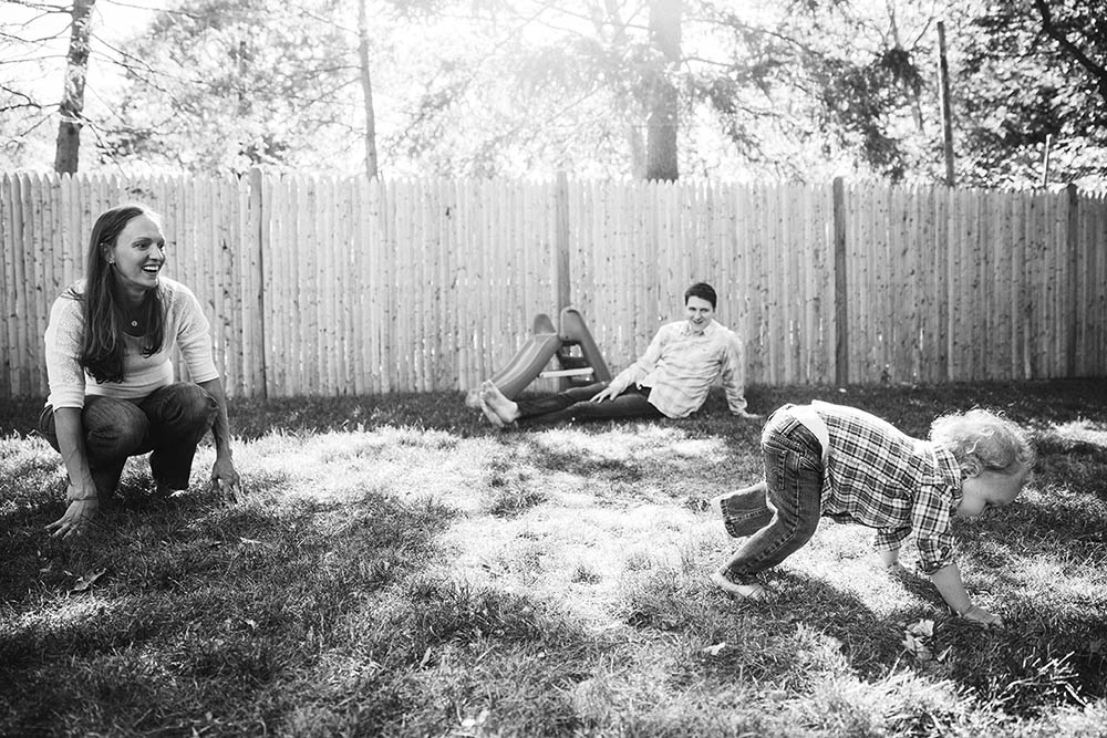 A documentary photograph of a family playing in their backyard during an in home family session in Boston