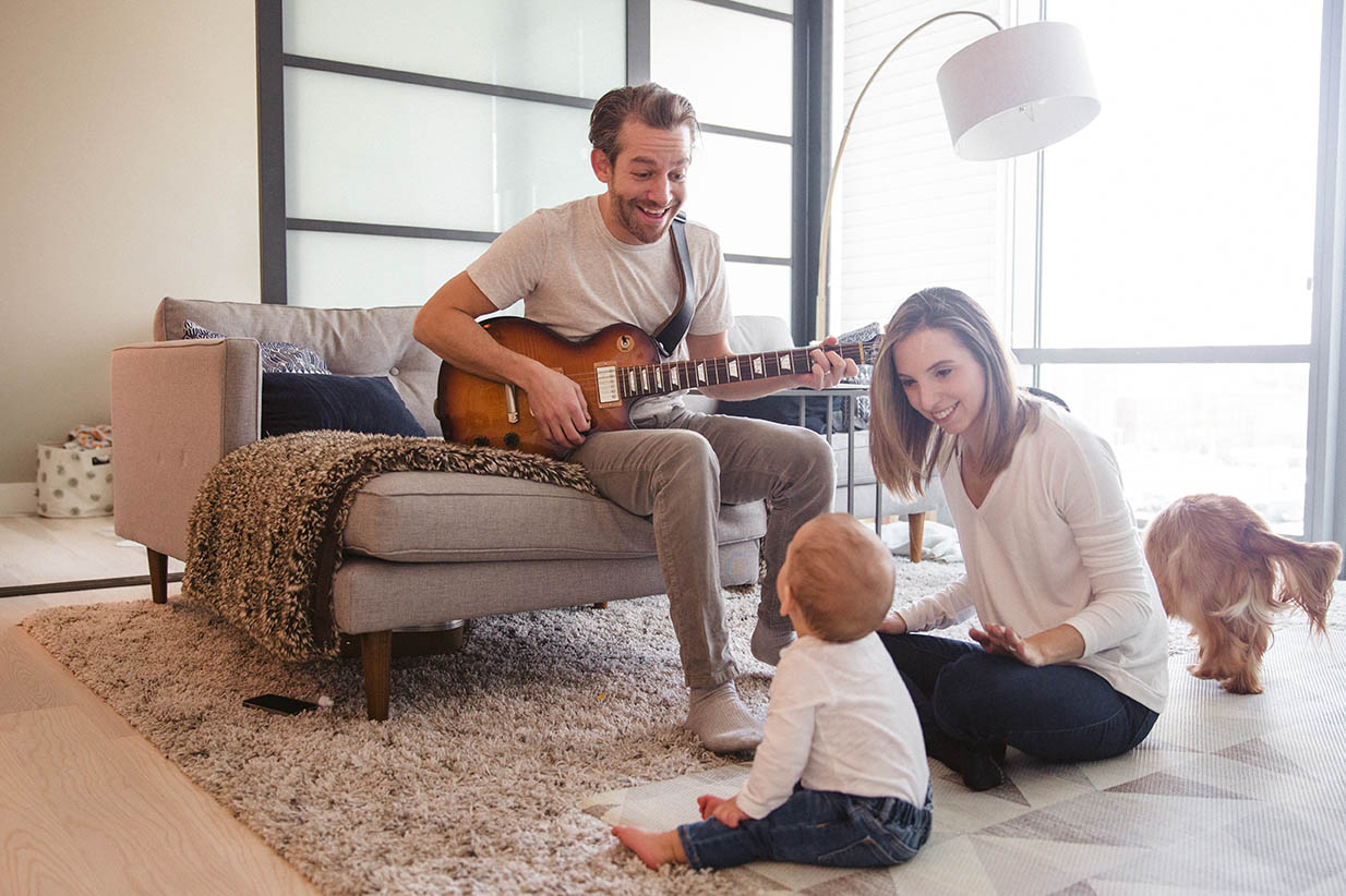 A documentary photograph of a family hanging out in their living room during an in home family session in Boston