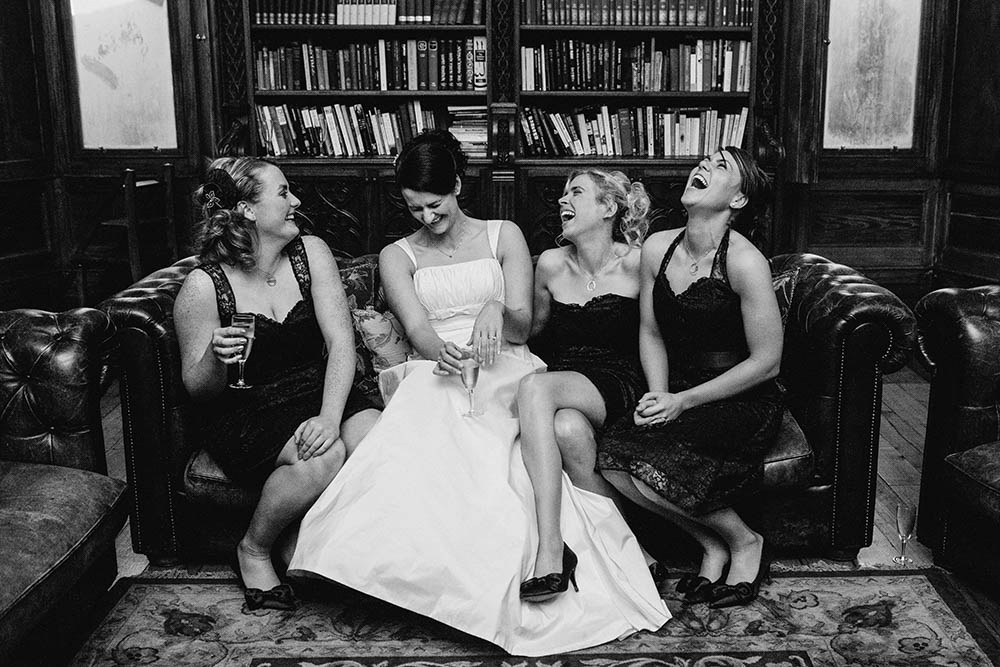 A documentary wedding a bride laughing with her bridesmaids during a Boston wedding
