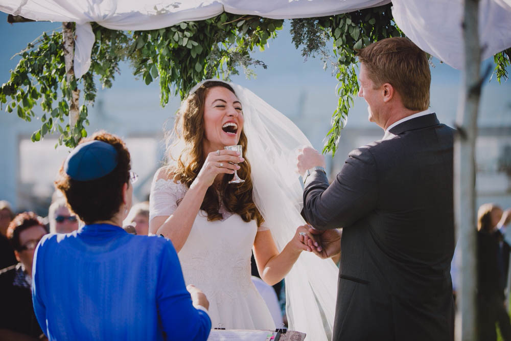 A documentary photograph of bride and groom laughing during their cape cod wedding ceremony