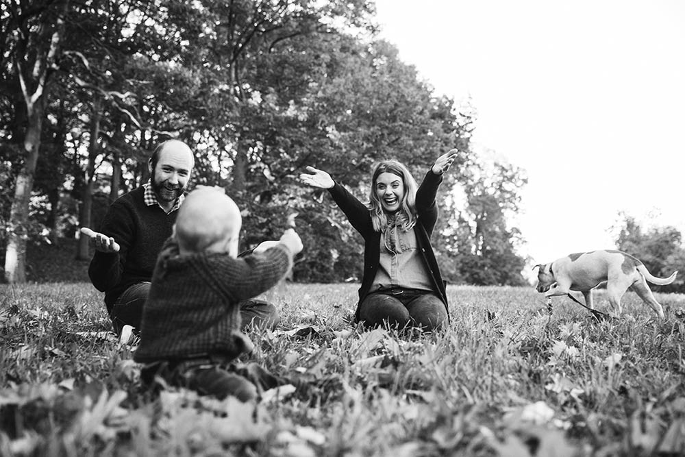 A documentary photograph of a family playing outside together during their Arnold Arboretum family session