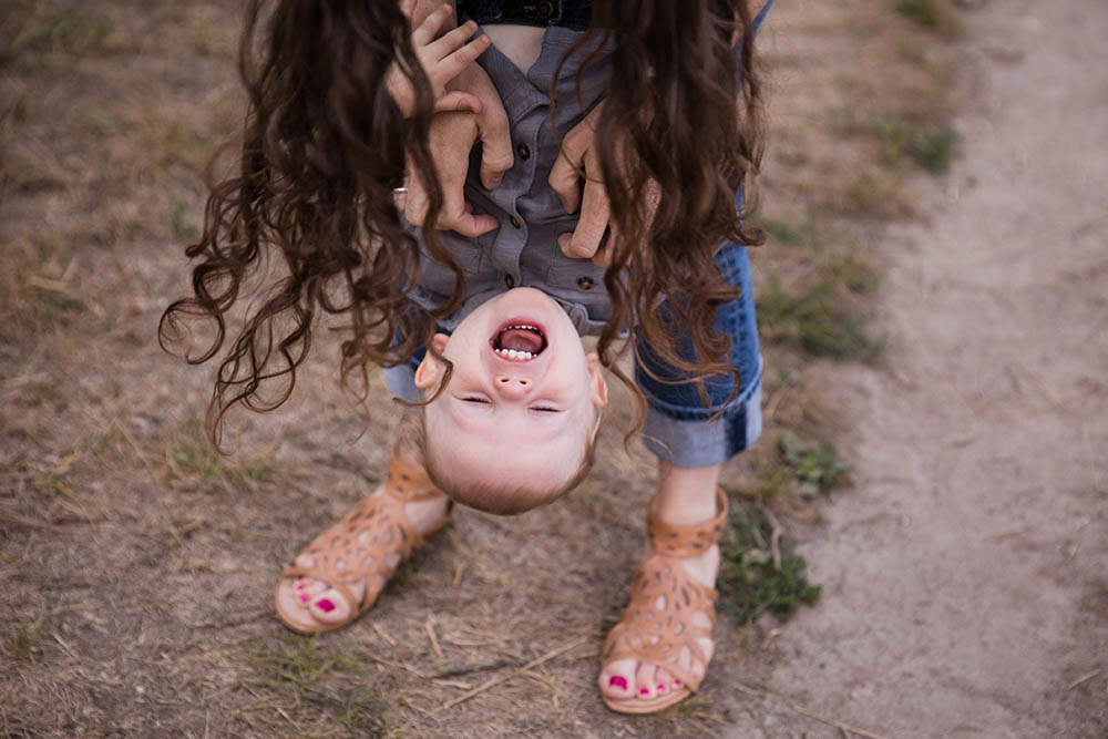 A documentary photograph of a mother playing with her son during their family session at the Arnold Arboretum