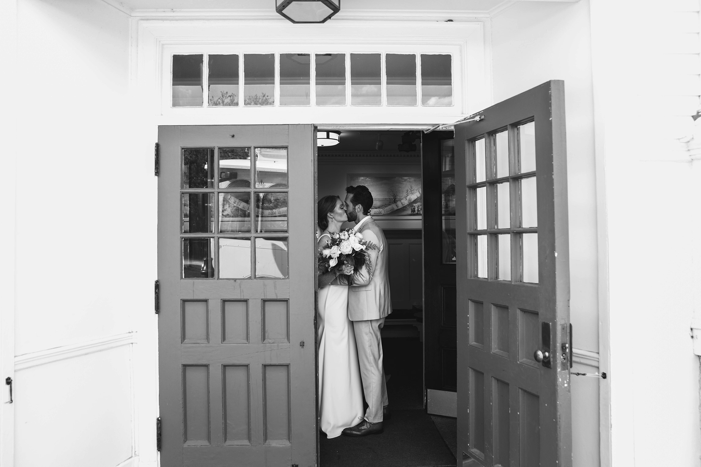 A documentary photograph featured in the best of wedding photography of 2019 showing a couple kissing as they leave the church as newly weds