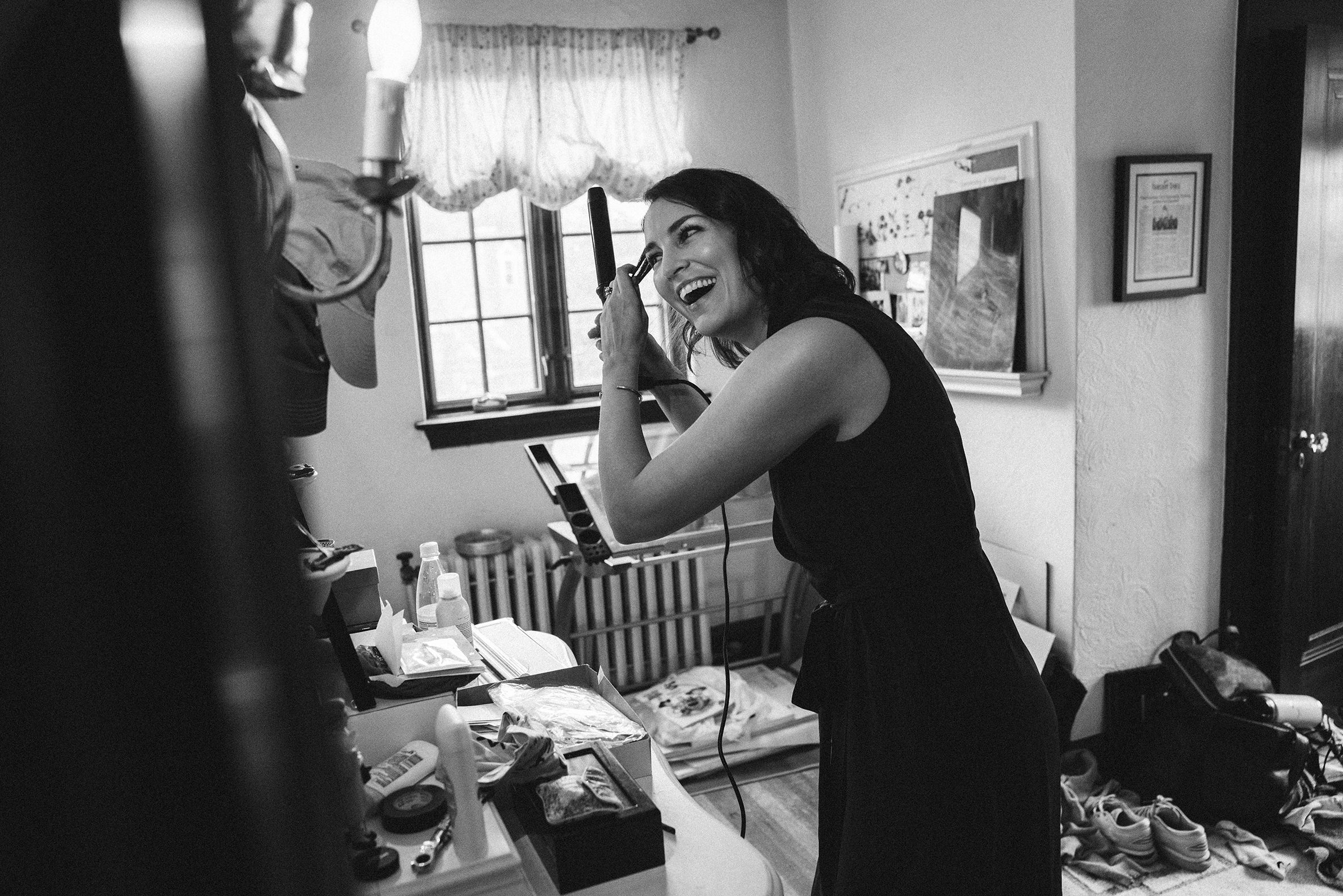 A documentary photograph featured in the best of wedding photography of 2019 showing a bridesmaid laughing and getting ready