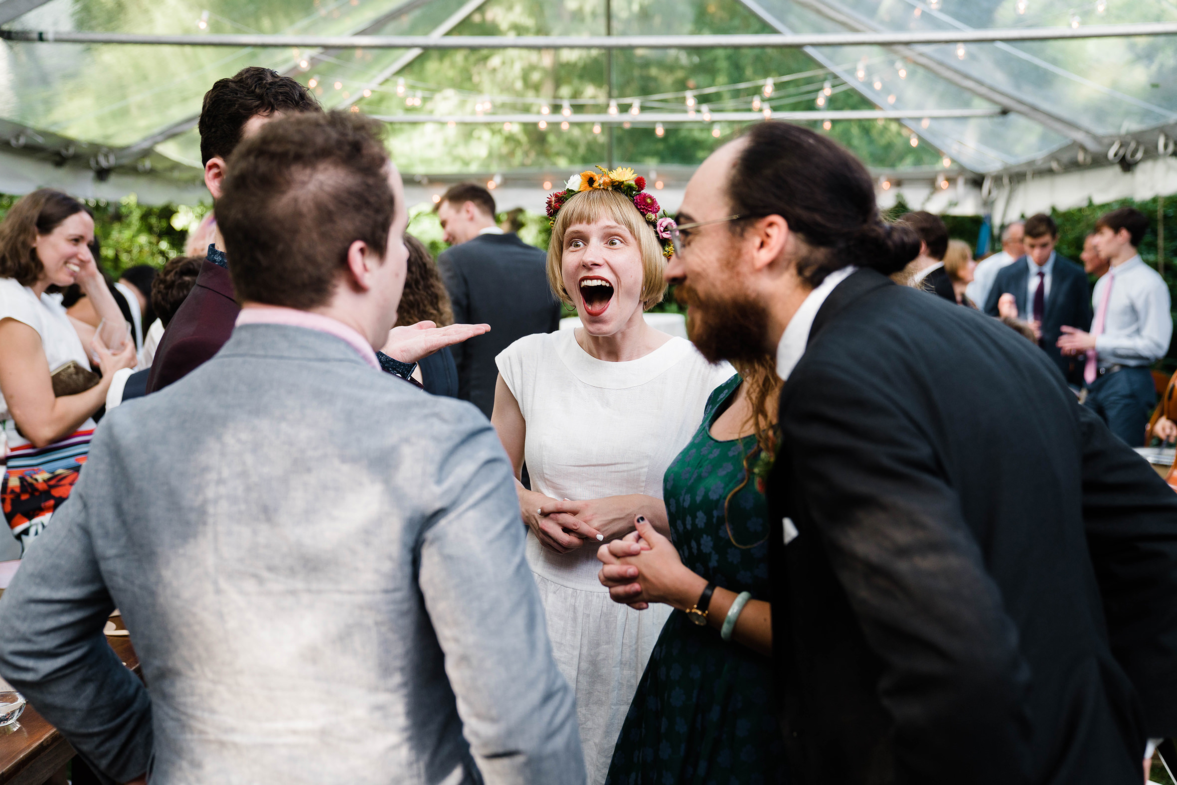 A documentary photograph featured in the best of wedding photography of 2019 showing a bride talking and laughing with friends during cocktail hour
