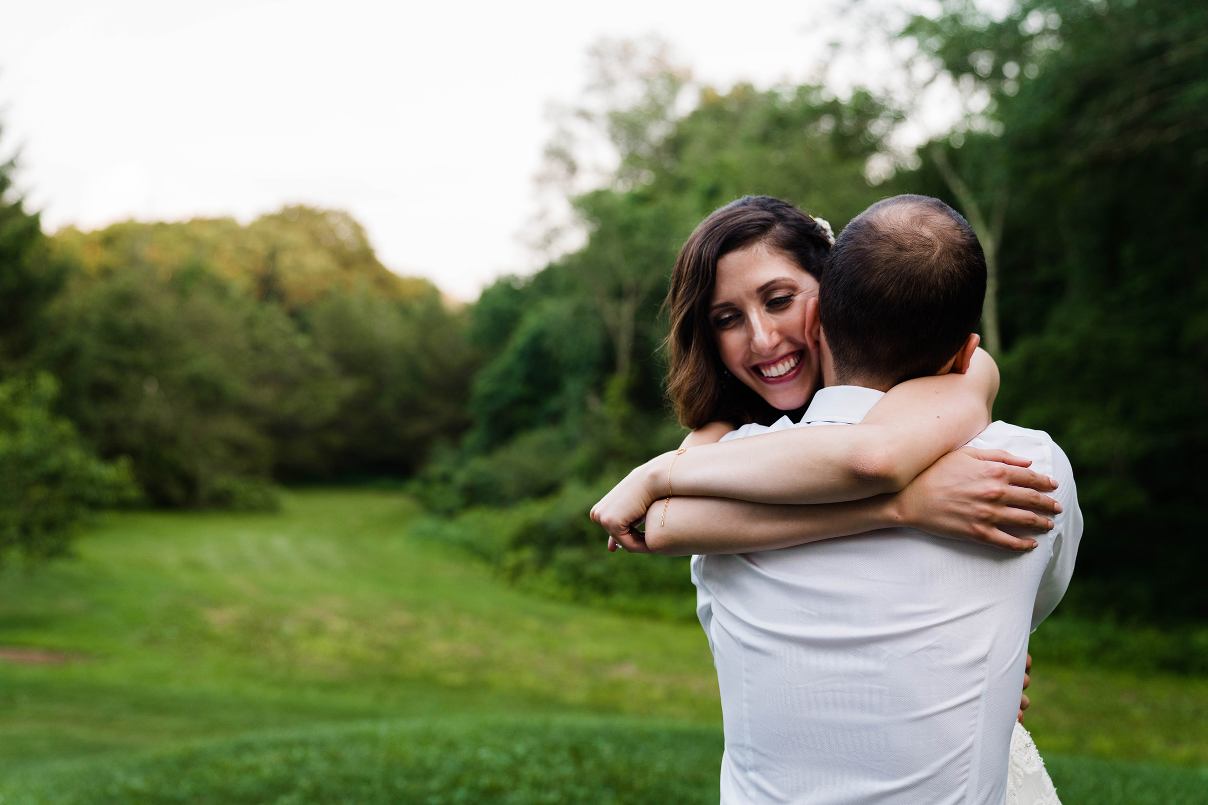 A documentary photograph featured in the best of wedding photography of 2019 showing a bride hugging her groom