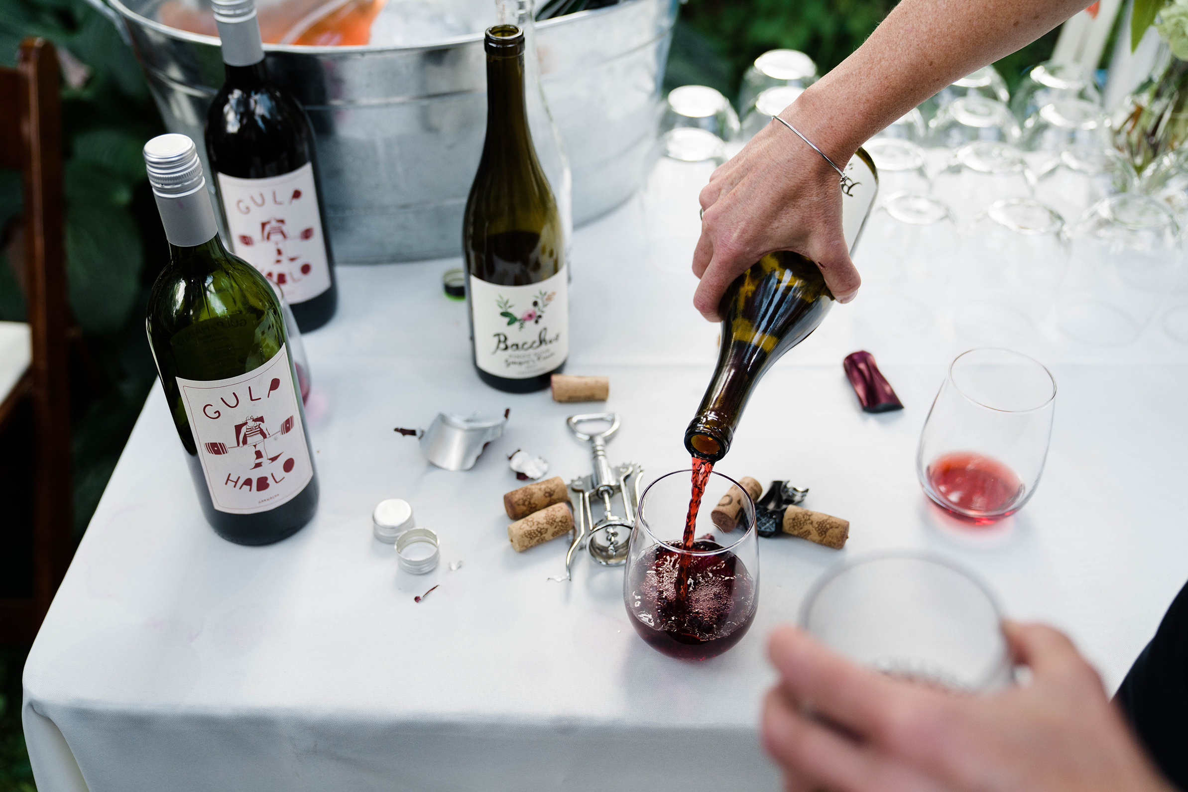 A documentary photograph featured in the best of wedding photography of 2019 showing wine being poured at a backyard wedding