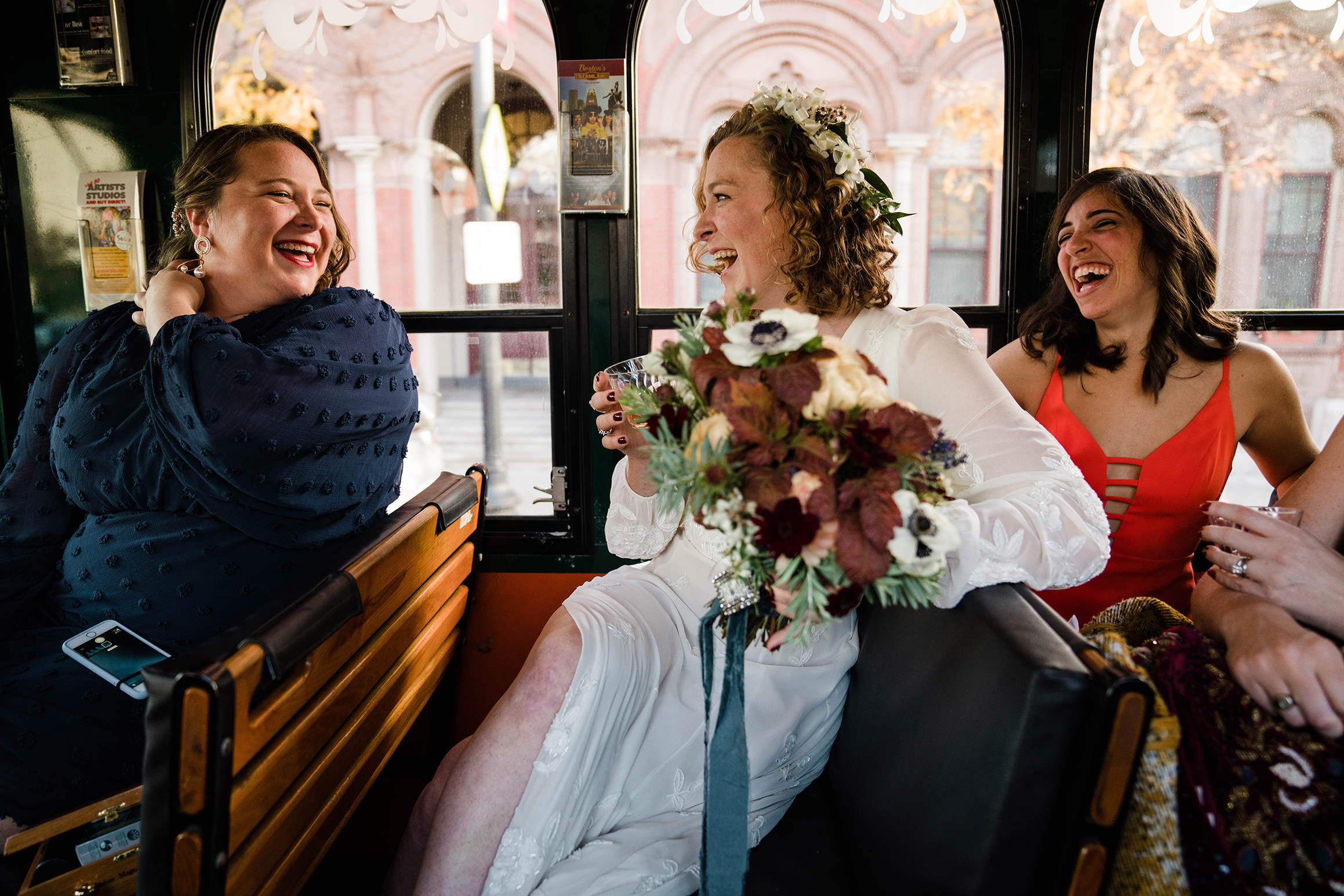 A documentary photograph featured in the best of wedding photography of 2019 showing a bride and her friends laughing on a trolley on the way to their wedding ceremony