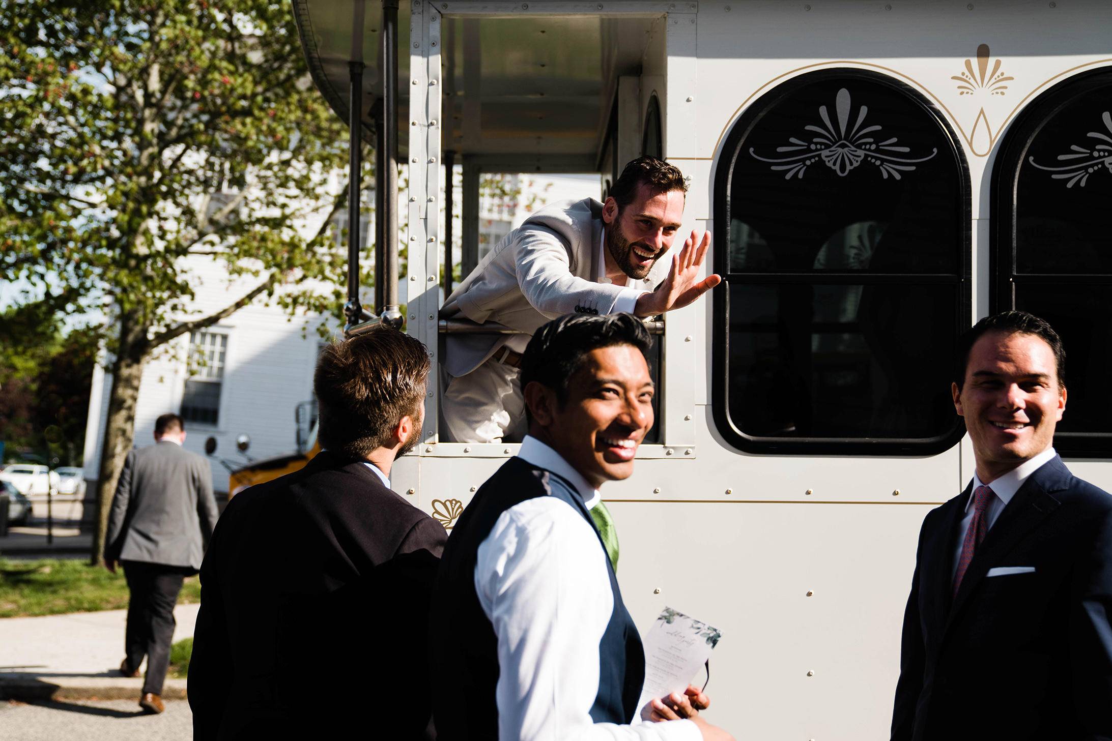 A documentary photograph featured in the best of wedding photography of 2019 showing a groom waving to the guests after his wedding ceremony