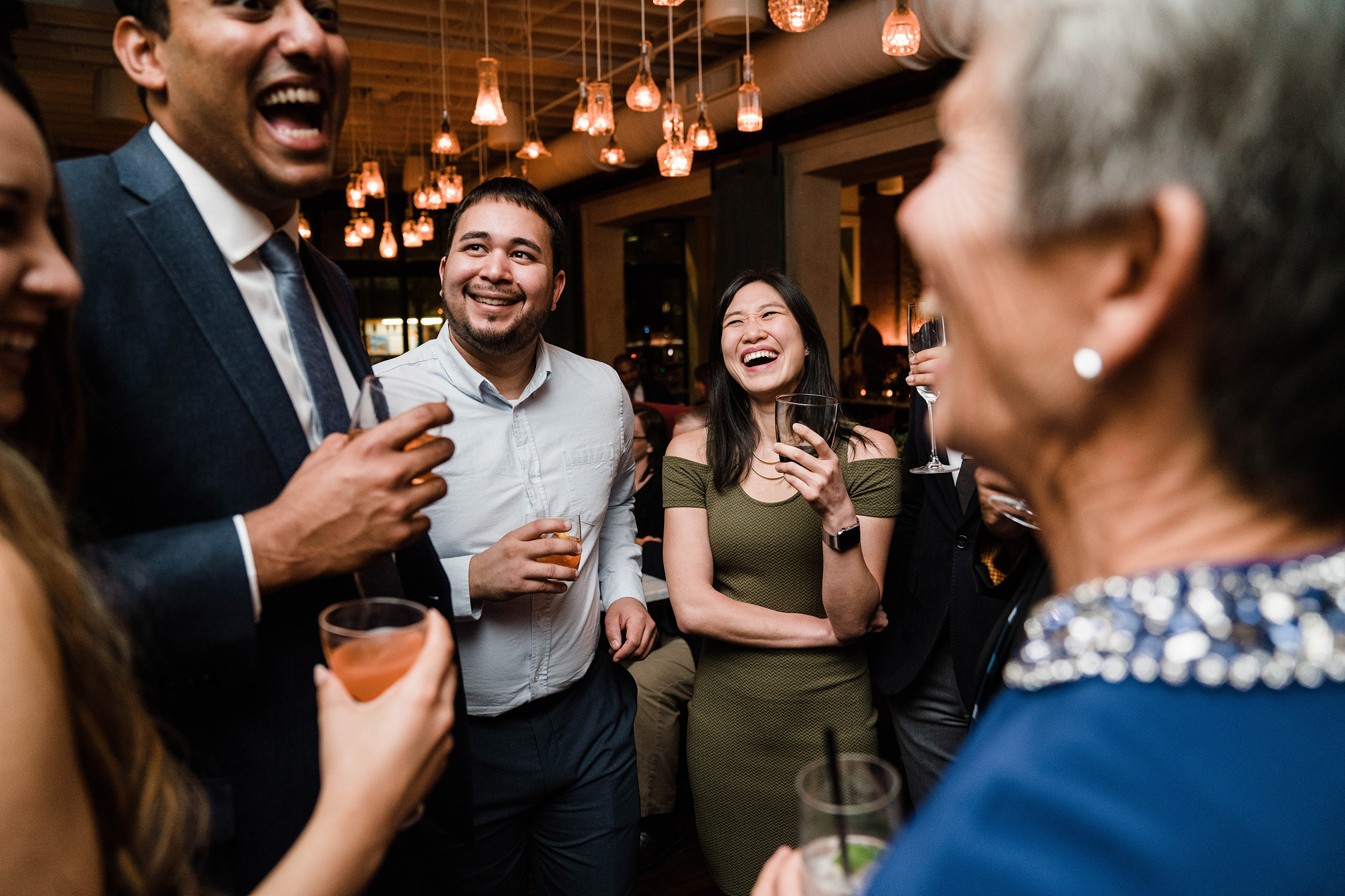 A documentary photograph featured in the best of wedding photography of 2019 showing guests laughing during cocktail hour