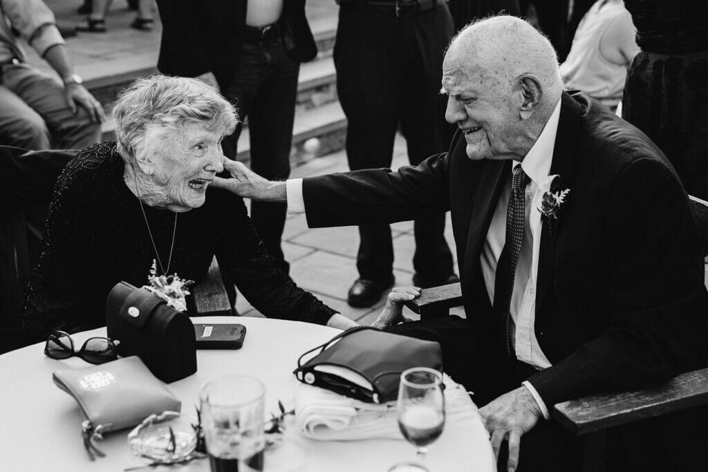 A documentary photograph featured in the best of wedding photography of 2019 showing an older couple laughing together during a wedding reception