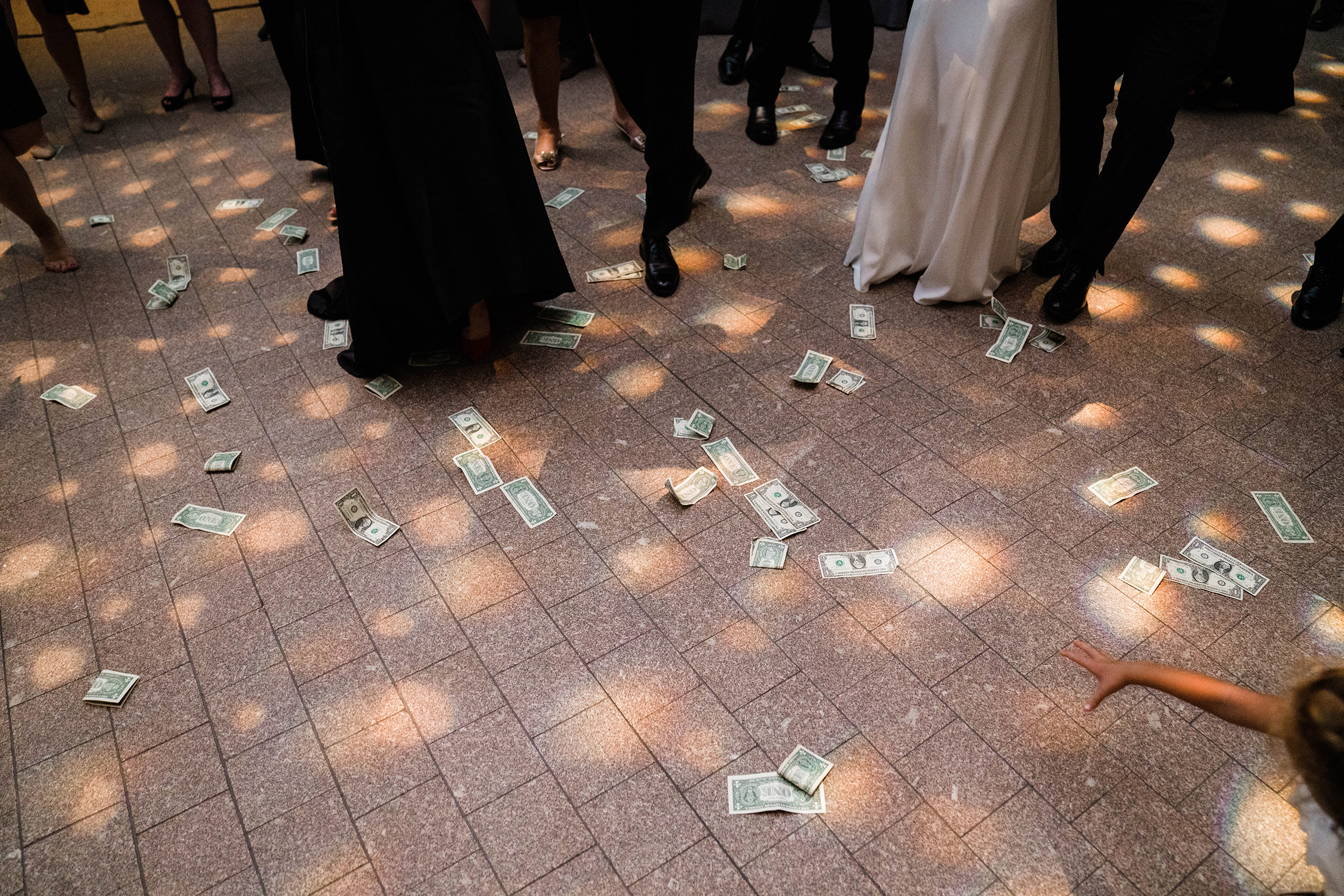 A documentary photograph featured in the best of wedding photography of 2019 showing money being thrown at a greek wedding