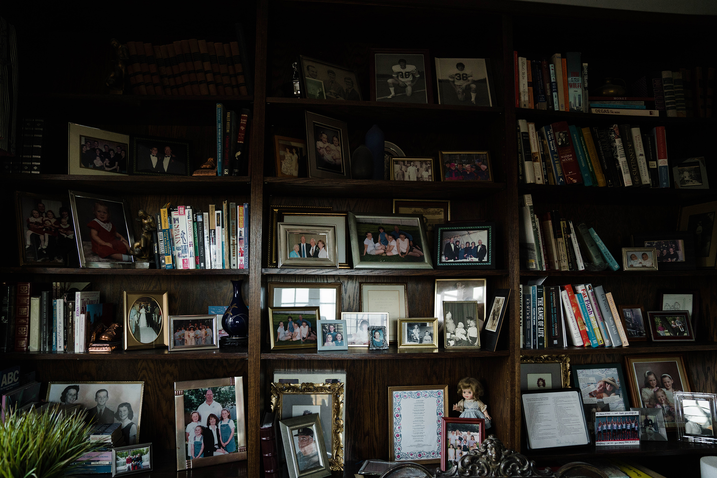 A documentary photograph featured in the best of wedding photography of 2019 showing a wall of family photographs at the bride's family home