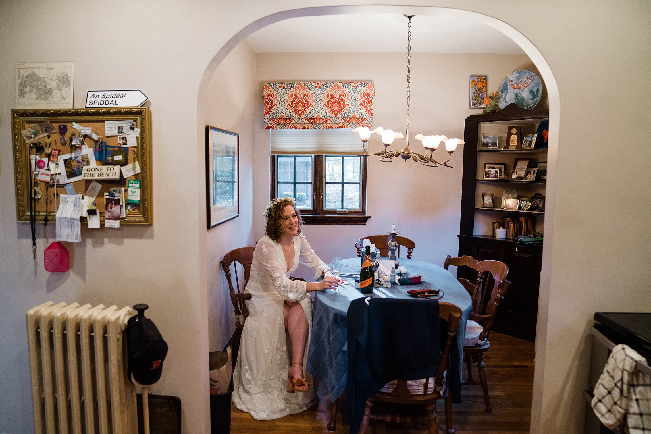 A documentary photograph featured in the best of wedding photography of 2019 showing a bride having a glass of champagne in her kitchen