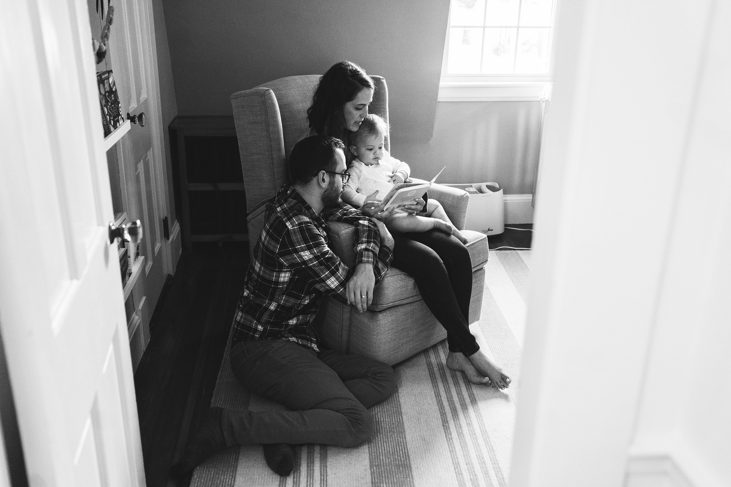 A best of boston family photograph of a family reading together in their baby's bedroom