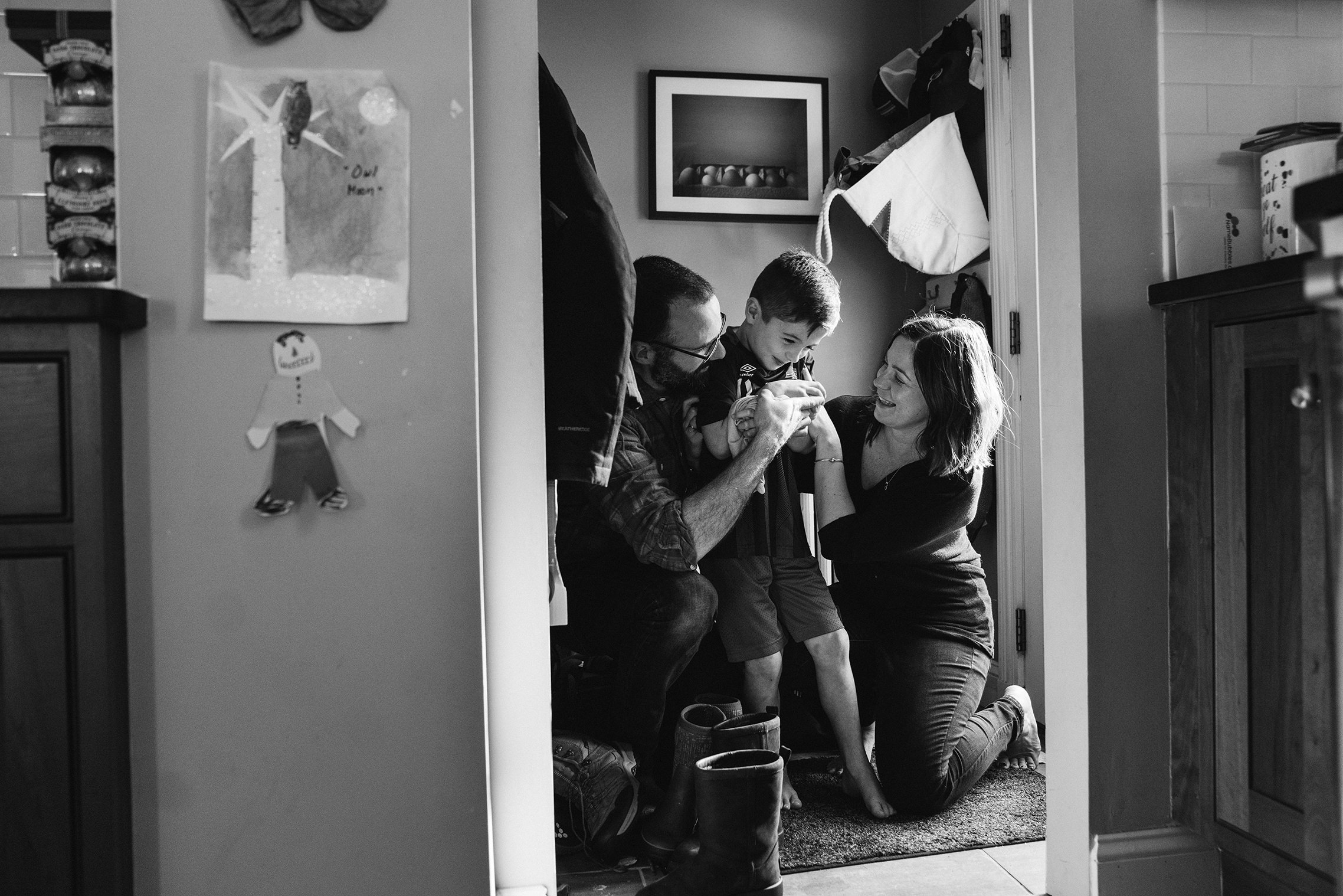 A documentary photograph of a family laughing together during their in home family session in Boston