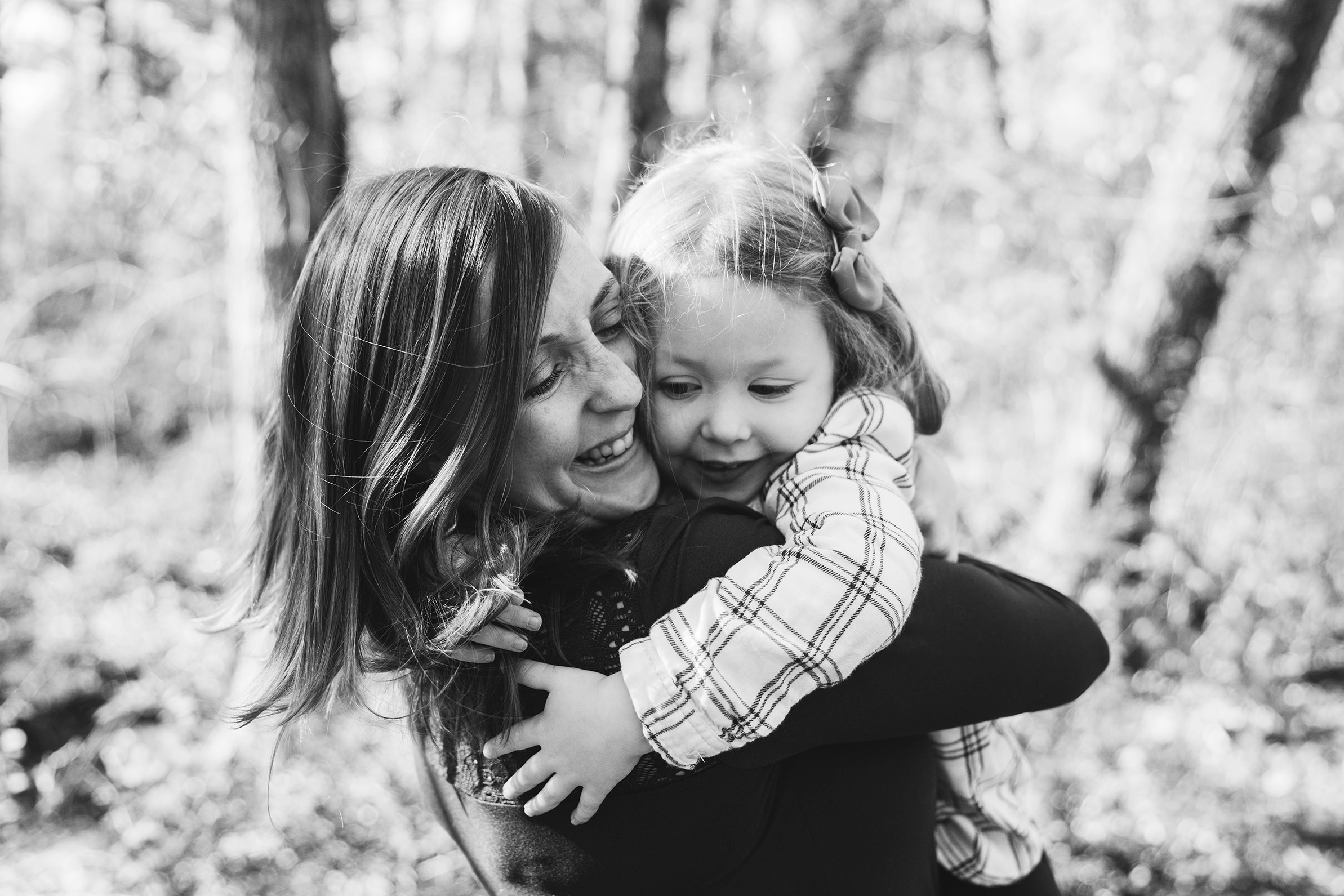 A documentary photograph of a mom hugging her daughter during a Boston family session